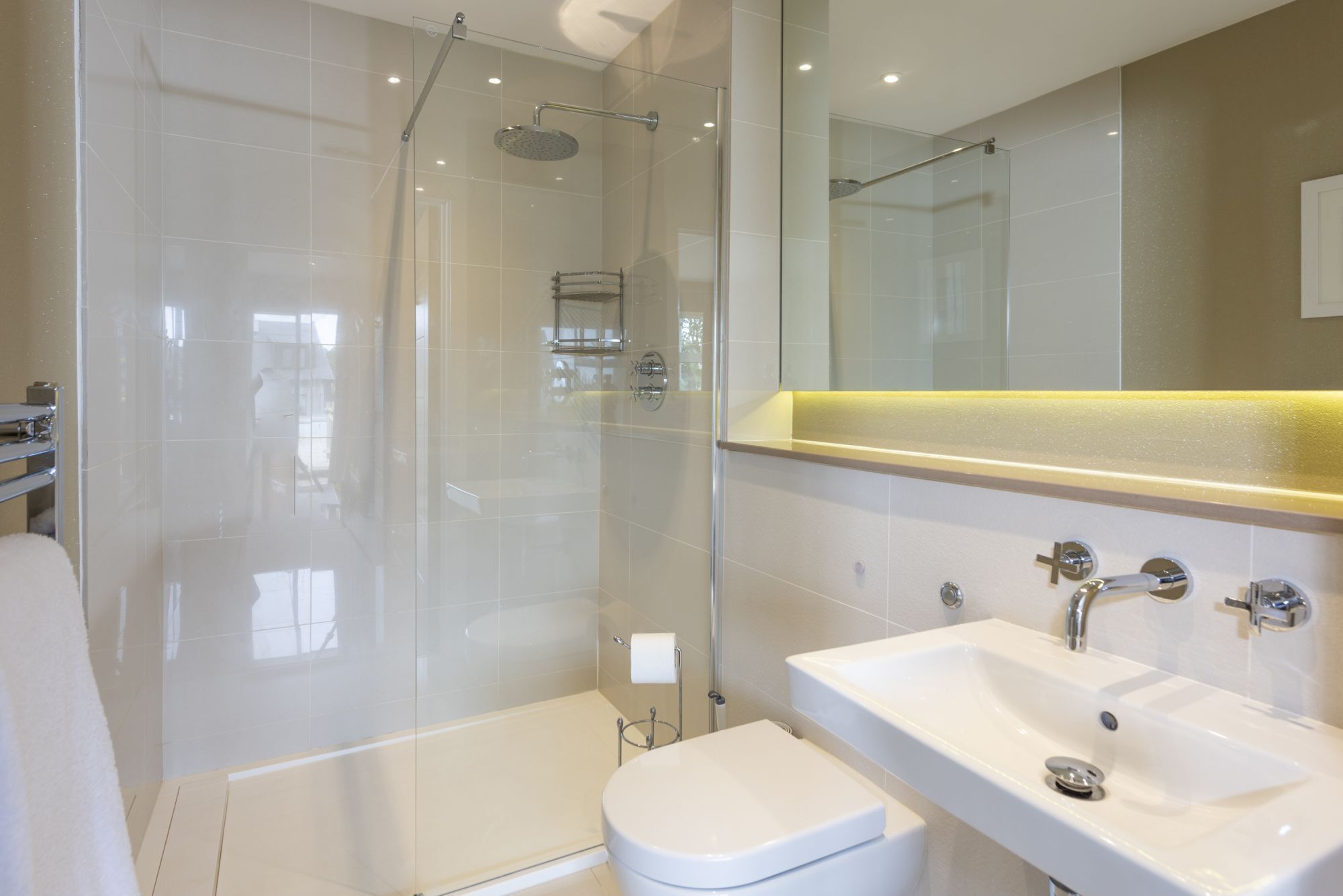 A modern bathroom with a glass-enclosed shower, a white sink, and a toilet.
