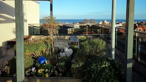 Un balcon avec vue sur le paysage urbain et la mer.