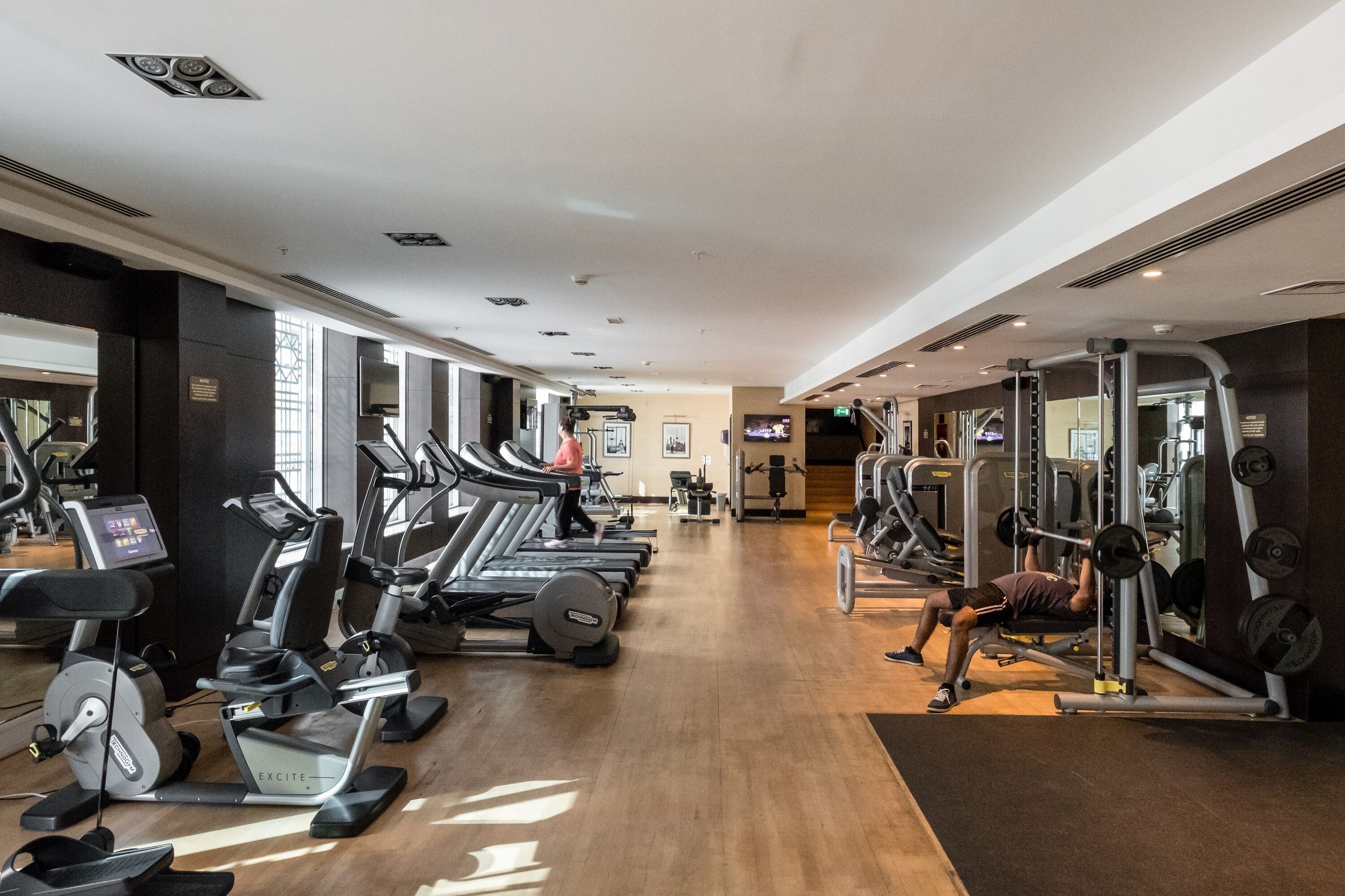 Ein Fitnessstudio mit Laufbändern, Crosstrainern und Gewichtsmaschinen.