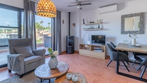 A modern living room with a sofa, coffee table, TV, and dining area. - Dimora Floriana by Sun & Sea (Moraira)