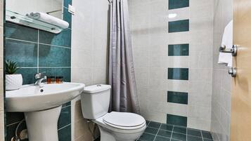 A bathroom with a white sink, toilet, and shower curtain.