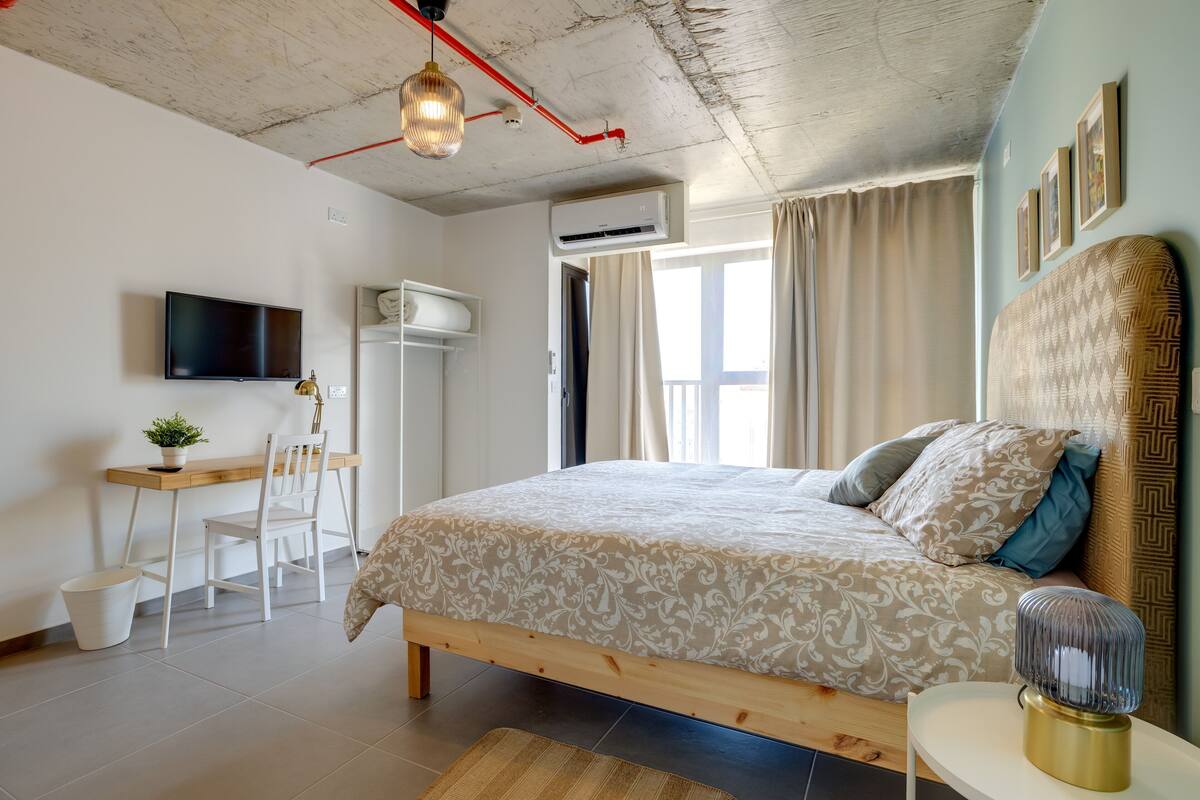 Een slaapkamer met een bed, een bureau, een stoel en een televisie.