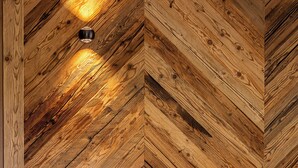 A room with a herringbone-patterned wooden wall and a light-colored sofa. - TOP 6 - Großzügiges Apartment mit Bergblick (Berwang)