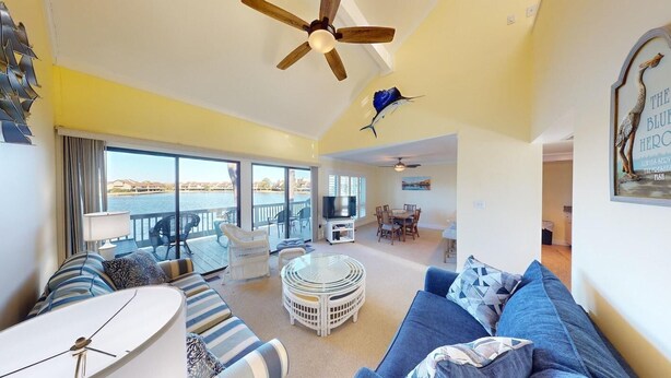 A spacious living area with a large sofa, a round coffee table, and a ceiling fan. - Lakeside Retreat in Gated Litchfield by the Sea (Pawleys Island)