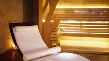A modern lounge chair with a white cushion, positioned in a room with wooden slats and a warm light source.