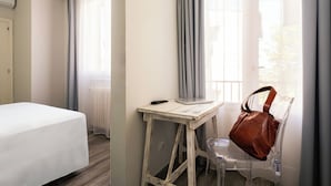 A hotel room with a bed, a desk, a chair, and a window with curtains. - Hotel Villa Bonelli (Fiesole)