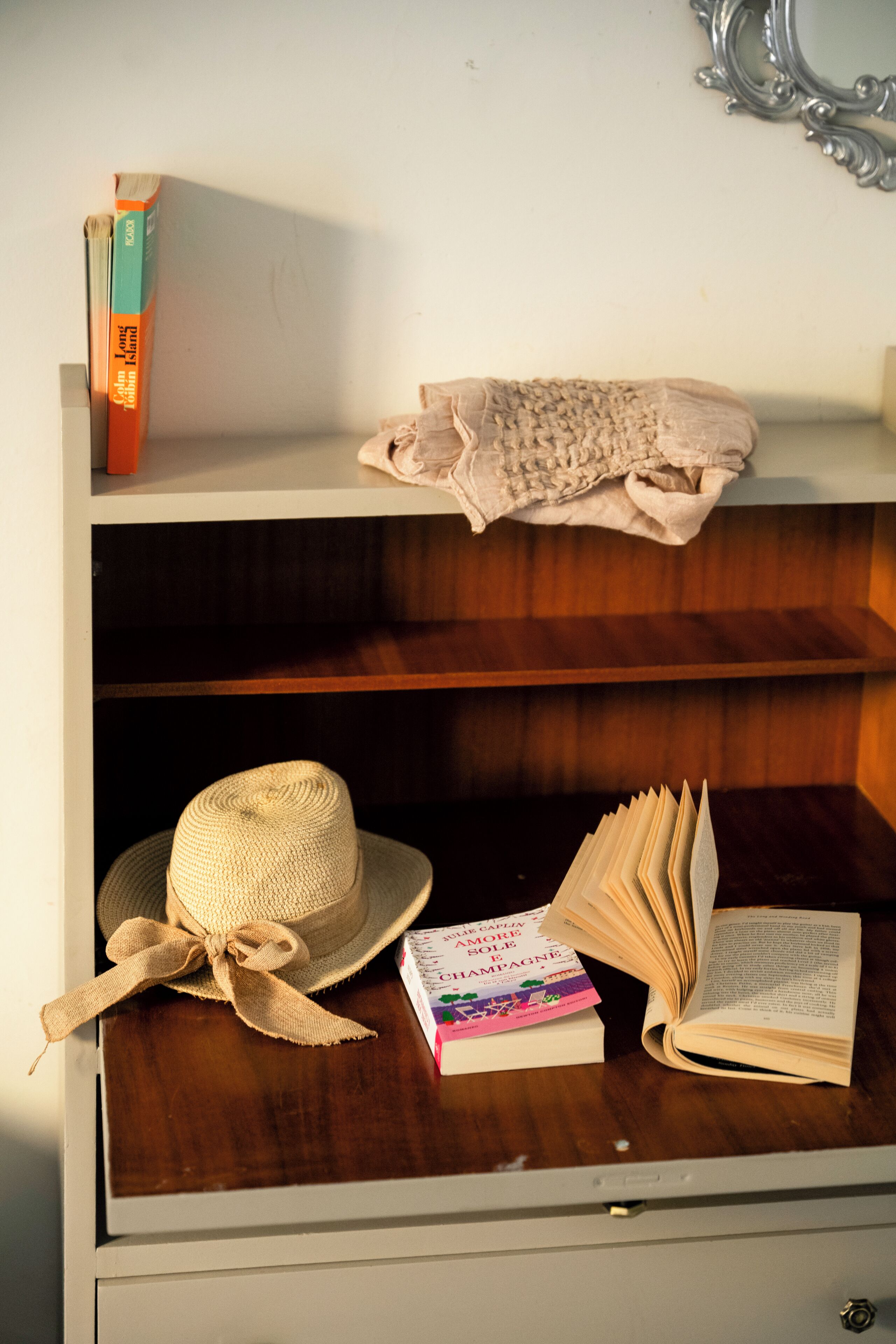 Een houten plank met een hoed, boeken en een opgevouwen doek.