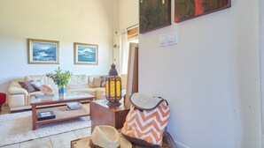 A living room with a sofa, coffee table, and decorative items. - Home in Comillas · 3 bedrooms · 4 beds · 3 baths (Ruiloba)