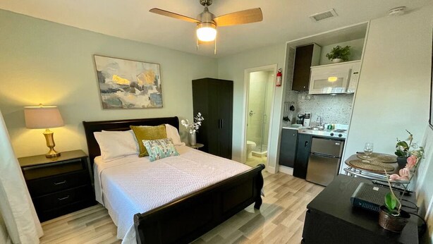 A bedroom with a bed, bedside table, lamp, and a ceiling fan. - Location! Location! Lovely Studio in Orlando (Orlando)