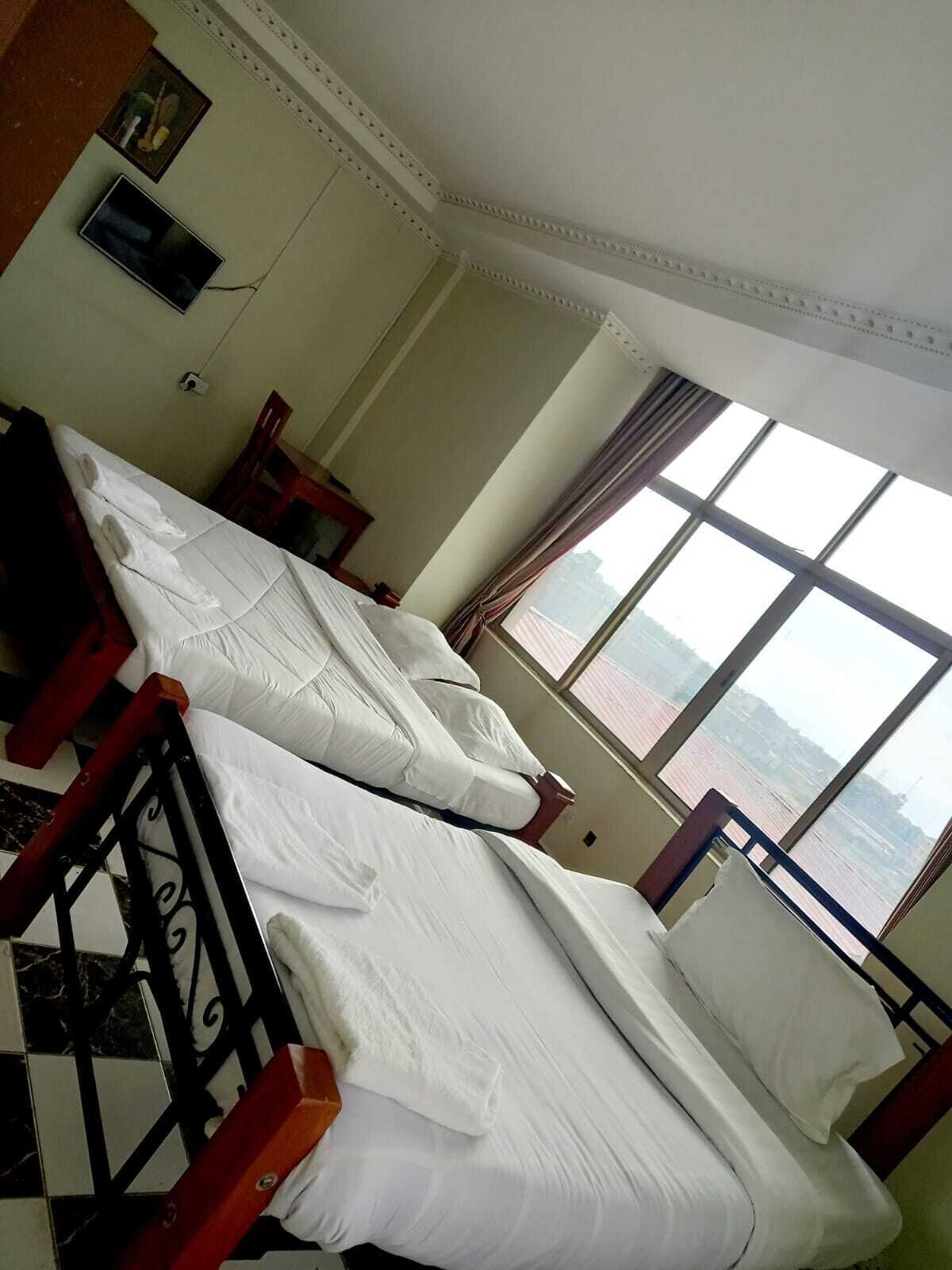 A room with a bed, a window, and a view of the water.