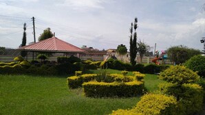 A park with a gazebo, well-maintained hedges, and a playground.