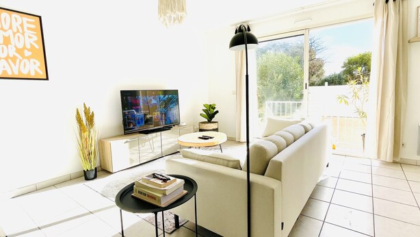 Una sala de estar moderna con un sofá, una mesa de centro, un televisor y una lámpara de pie.