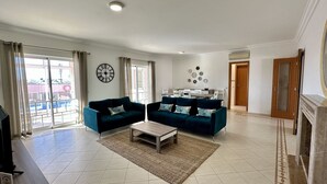A spacious living room with two sofas, a coffee table, and a dining area in the background.