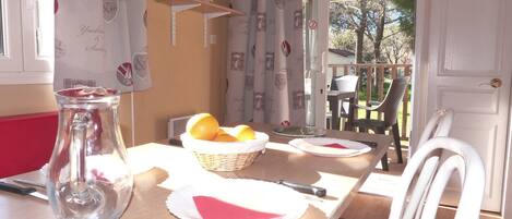 A dining table with a pitcher, a basket of lemons, and plates with napkins.