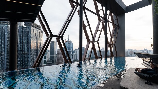 A rooftop infinity pool with a city view, surrounded by a geometric metal structure. - KLCC CityViewStayCation AT Scarletz Suites By HAPYHOME (Kuala Lumpur)
