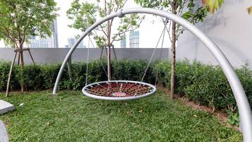 Relax in style with a serene outdoor swing set, suspended in a lush garden.