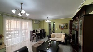 Ein Wohnzimmer mit einer Couch, einem Couchtisch und einem Essbereich mit Stühlen und einem Tisch.