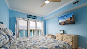 A bedroom with a bed, a dresser, a television, and a sign on the wall.
