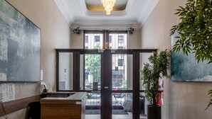 A lobby with a reception desk, seating area, and a large plant.