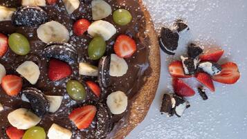 A dessert with chocolate, strawberries, bananas, and green grapes.