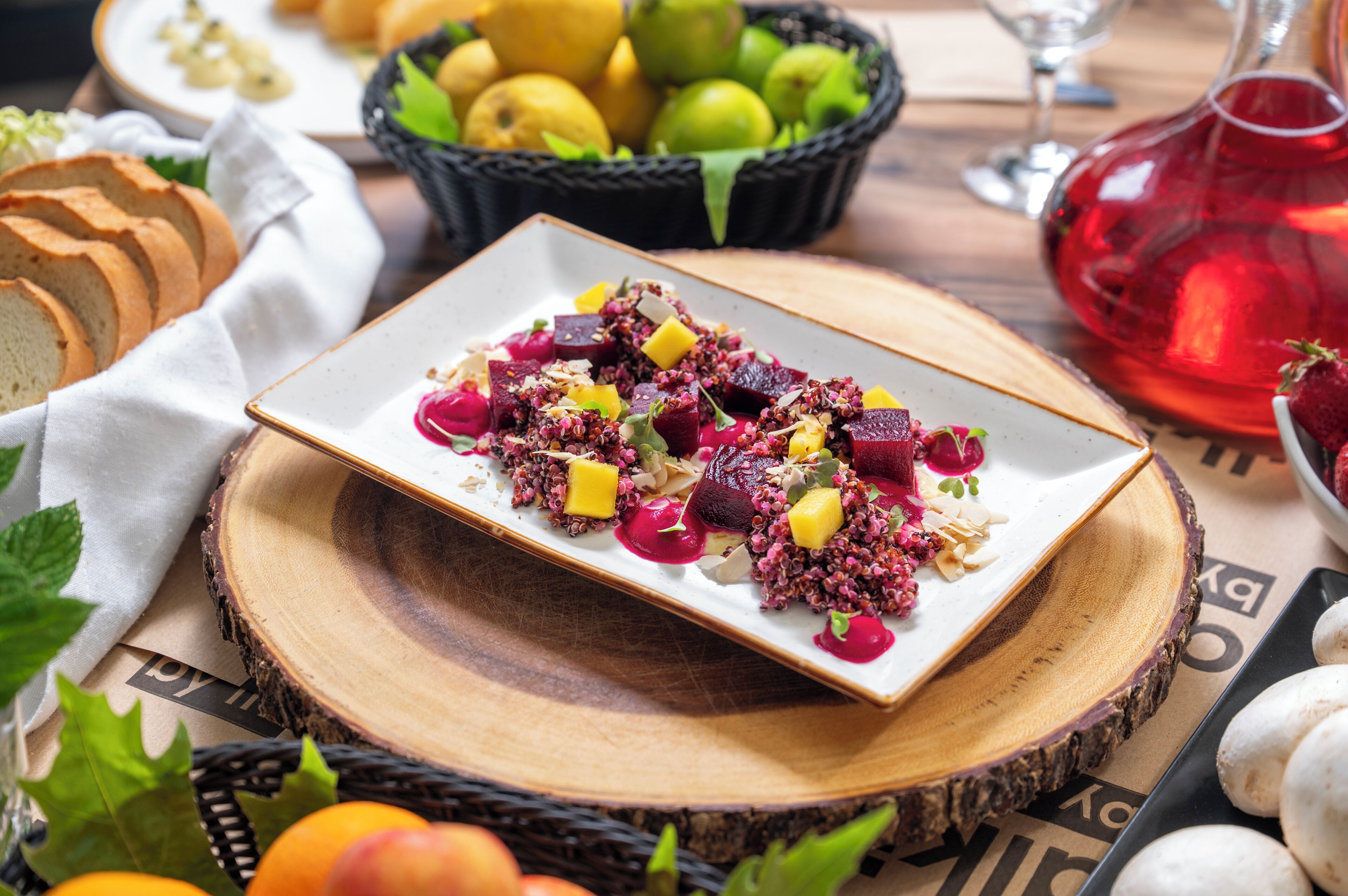 Une assiette remplie de divers fruits et de céréales, entourée de pain et d’un panier de fruits.
