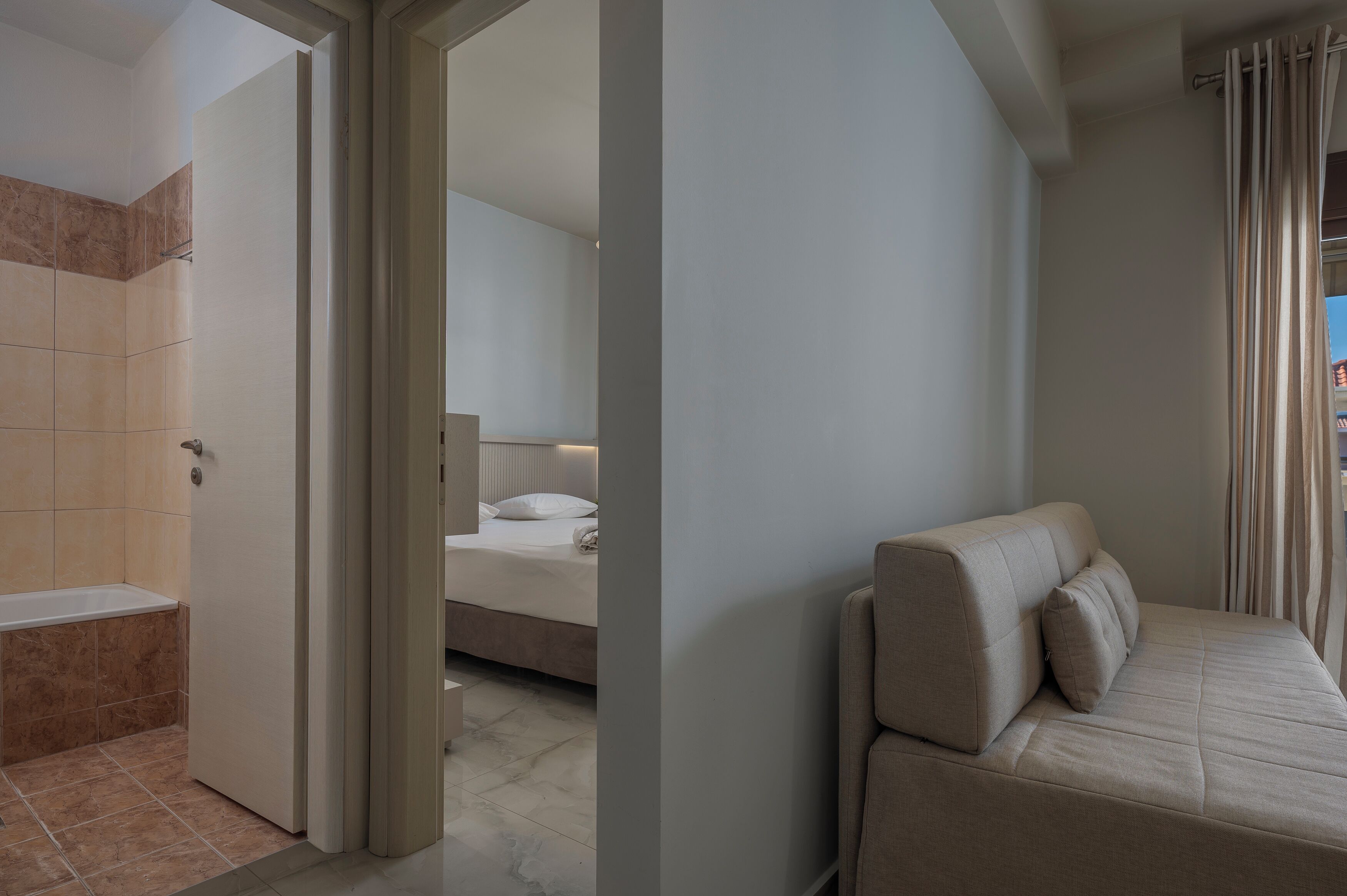 Ein Hotelzimmer mit Bad, Bett und einer Couch.