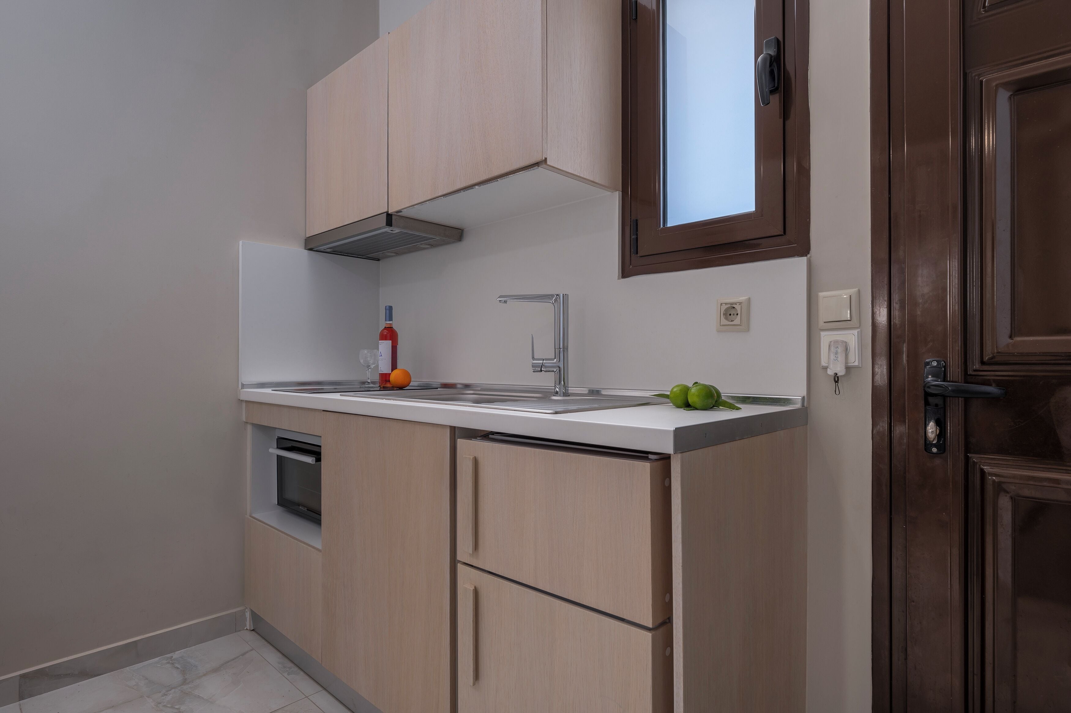 Una cucina con forno integrato, lavello e pensili.