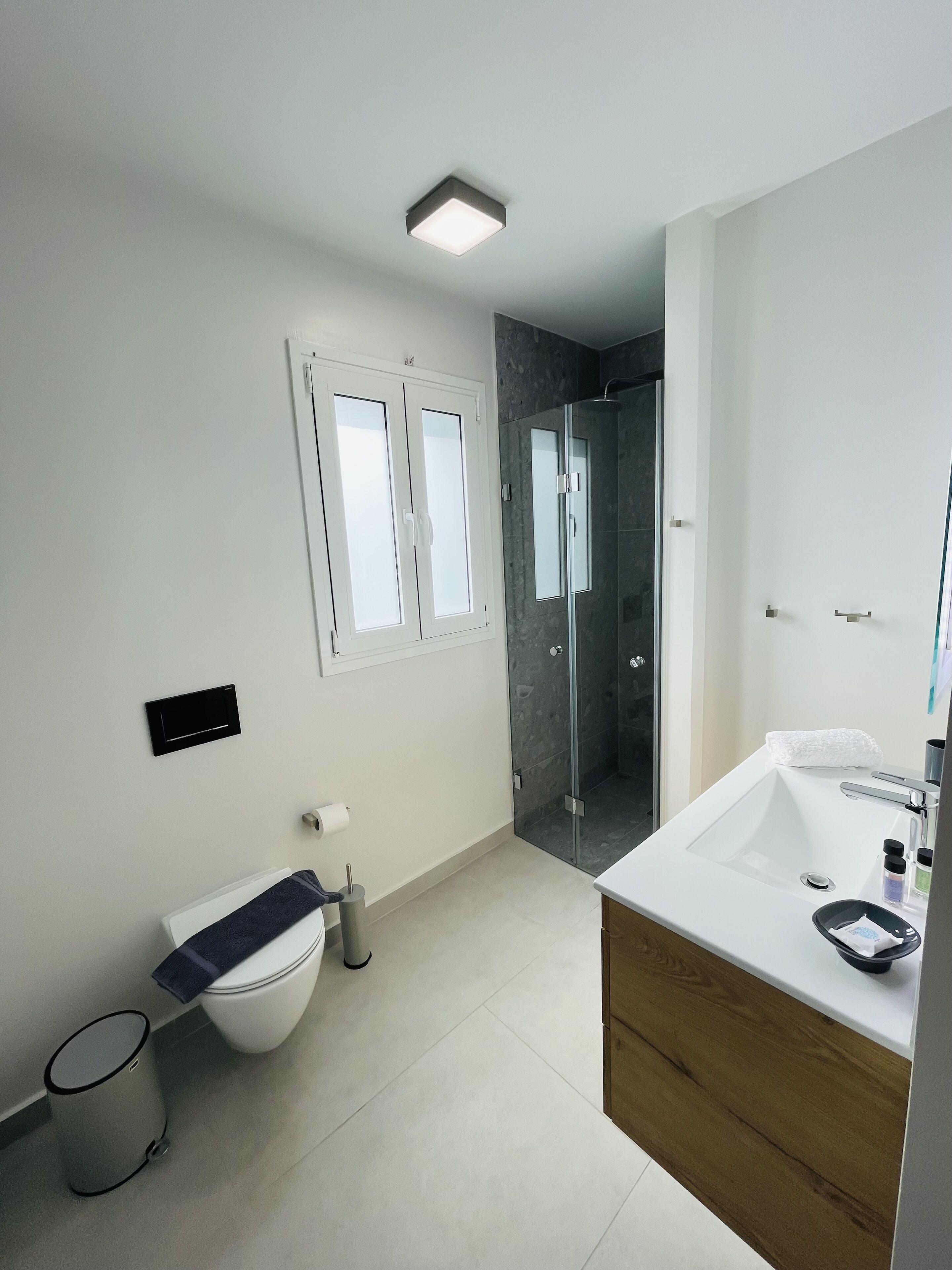 Een moderne badkamer met toilet, bidet, douche en wastafel.