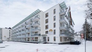 Un edificio de varios pisos con balcones y un cartel que indica un complejo de esquí.
