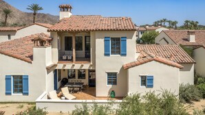 A two-story house with a tiled roof, blue shutters, and a balcony. - Newly Renovated! Designer Chic 2-Story Townhome, Views, Private Patio, Garage, Pet Friendly! (L97) (La Quinta)
