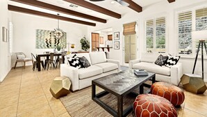 A modern living room with a white sofa, a coffee table, and a dining area with a table and chairs. - Newly Renovated! Designer Chic 2-Story Townhome, Views, Private Patio, Garage, Pet Friendly! (L97) (La Quinta)