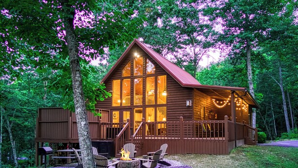 Une cabane dotée d’une terrasse, d’un foyer extérieur et de meubles de jardin.