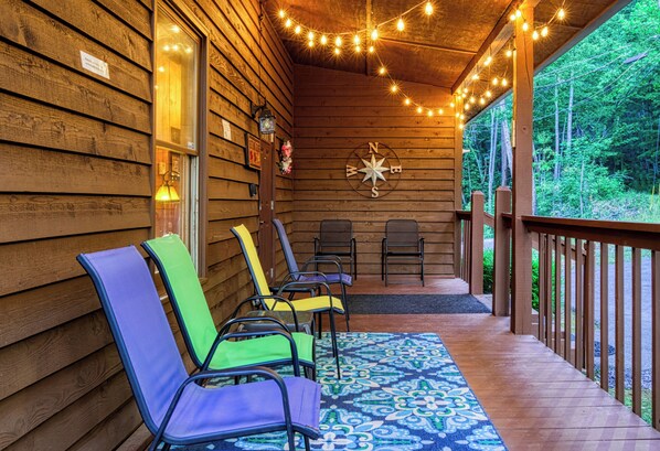 Une terrasse en bois avec des chaises et une décoration murale représentant une boussole.