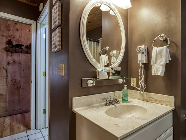 Une salle de bain avec un grand miroir, un lavabo et un porte-serviettes.