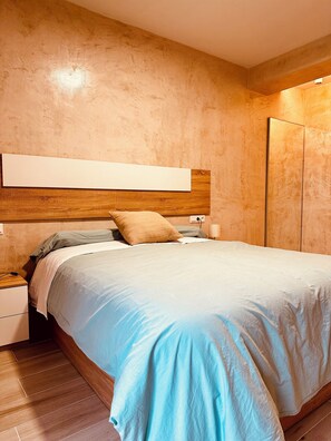 Relax in this serene bedroom with a large bed, nightstand, and wardrobe.