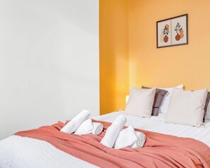 A hotel room with a bed, pillows, a blanket, and a framed picture on the wall. - 2b Studio with Smart TV, Netflix & Free Parking (Stoke-on-Trent)