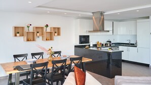 Una cucina moderna con mobili bianchi, un piano di lavoro nero e un'isola centrale.
