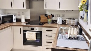 Cozinha compacta com micro-ondas, torradeira e forno.