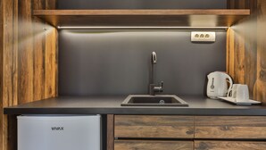 A compact kitchen with a built-in dishwasher, a sink, and a coffee maker. - Hotel Vladimir (Budva)