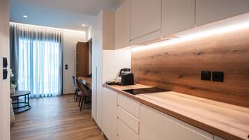 Een moderne keuken met houten aanrechtbladen, een inbouwfornuis en witte kasten.