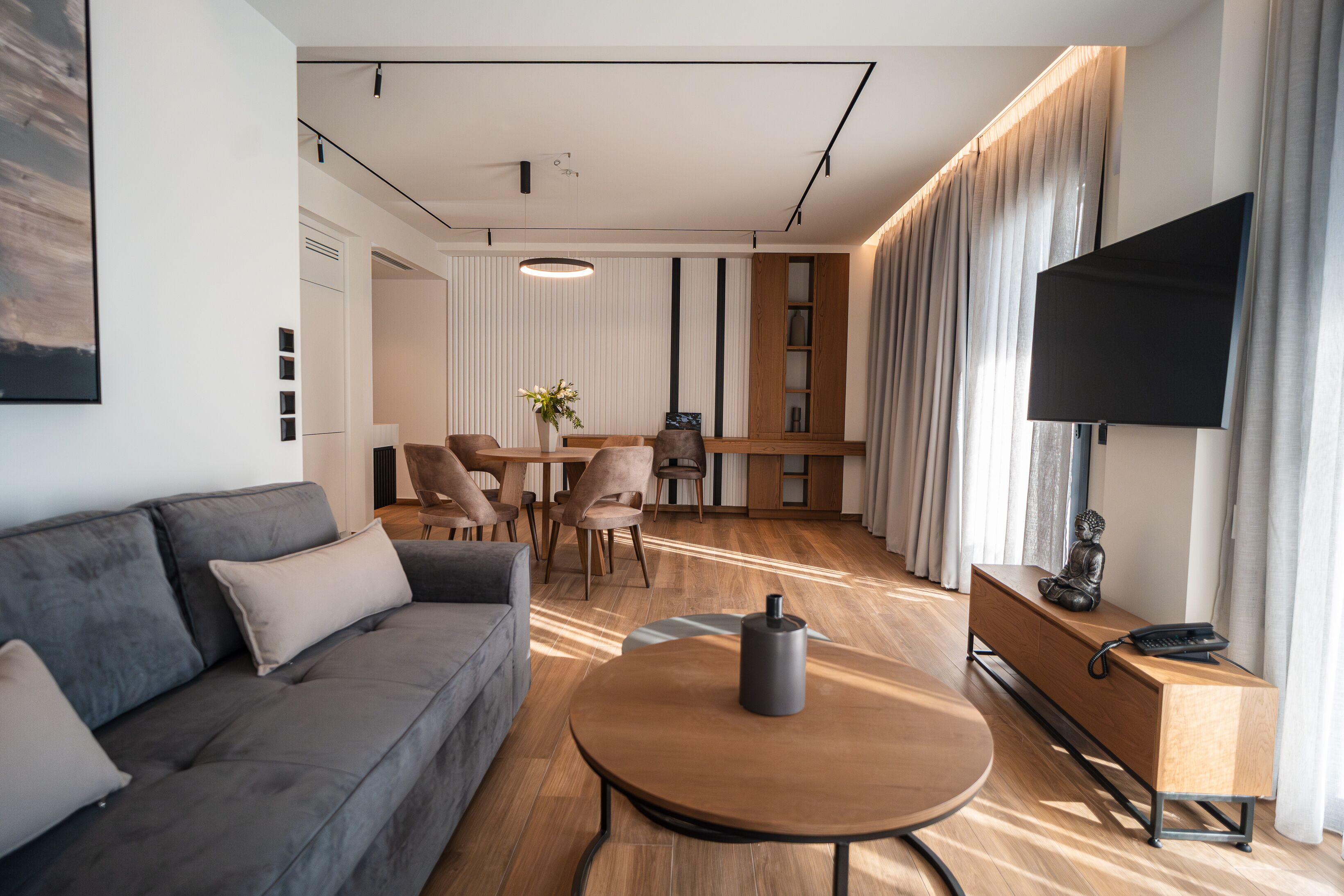 A modern living room with a sofa, coffee table, and a TV on a stand.
