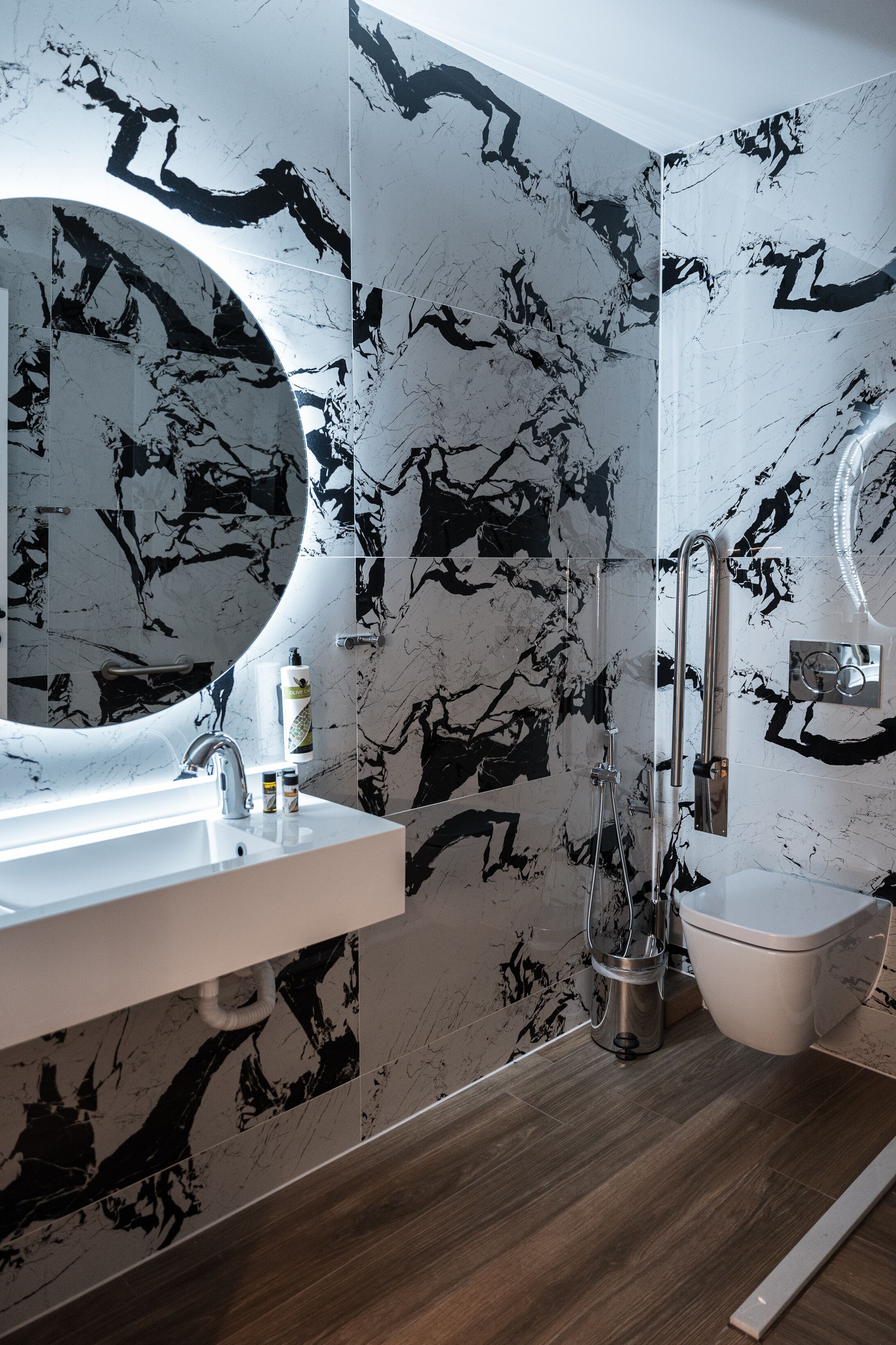 A bathroom with a white sink, a large mirror, a toilet, and a shower area.