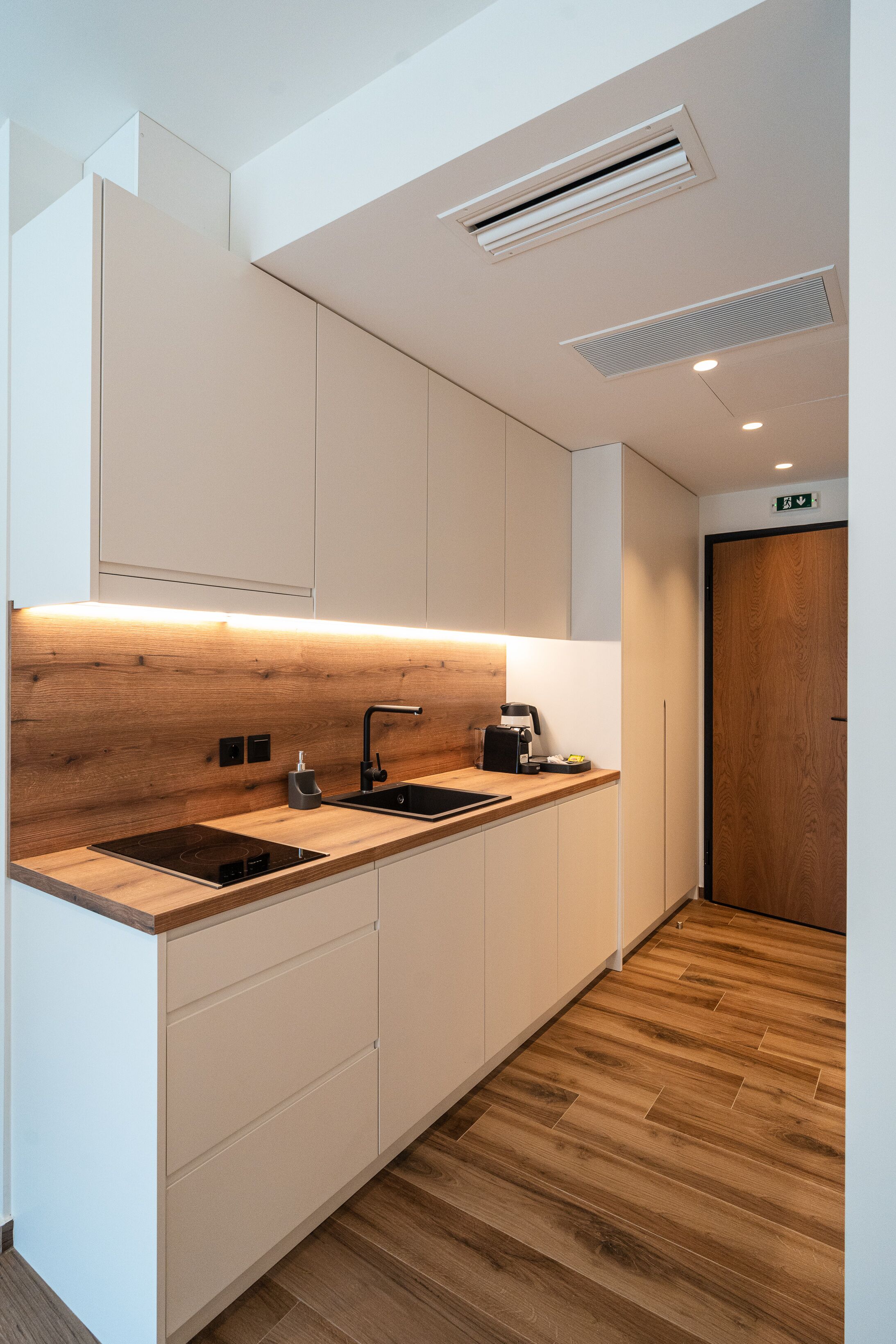 A modern kitchen with wooden countertops, a built-in sink, and a coffee machine.
