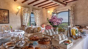 A breakfast buffet with various food items, a pitcher, cups, and a view of the outdoors. - Tenuta Guardastelle (San Gimignano)