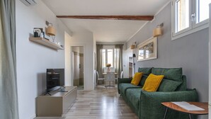 A modern living room with a green sofa, a TV, and a wooden cabinet. - House on the Roof - Florence Dolce Vita (Firenze)