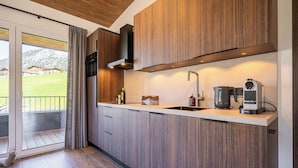 Una cocina moderna con armarios de madera, estufa integrada y cafetera.
