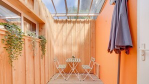 A wooden deck with a table and chairs, a hanging plant, and a ceiling fan. - Nice little townhouse Bordeaux (Bordeaux)