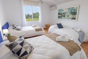 A hotel room with two beds, a painting, and a view of greenery. - Fidalsa Divine Hiding (Algorfa)