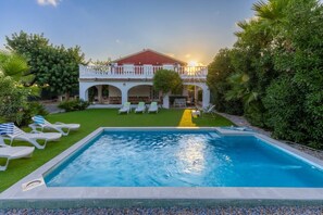 A swimming pool with lounge chairs and a building with a red roof and white balcony. - Fidalsa Divine Hiding (Algorfa)