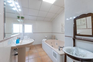 A bathroom with a large bathtub, a sink, and a mirror. - Fidalsa Divine Hiding (Algorfa)